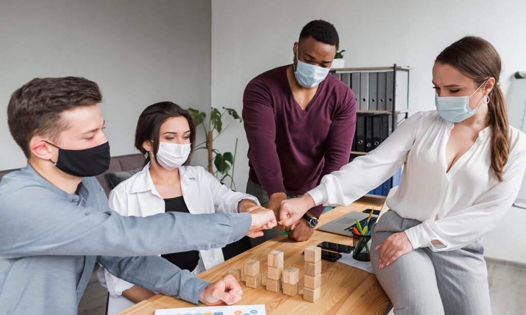 Colleagues bumping fists across a desk